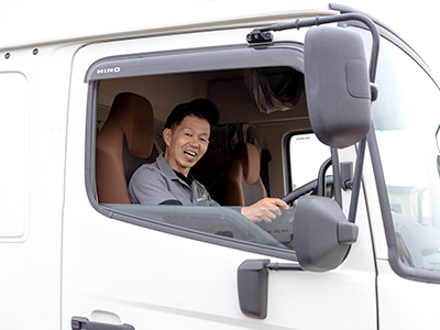 トラックの運転席で笑うドライバー